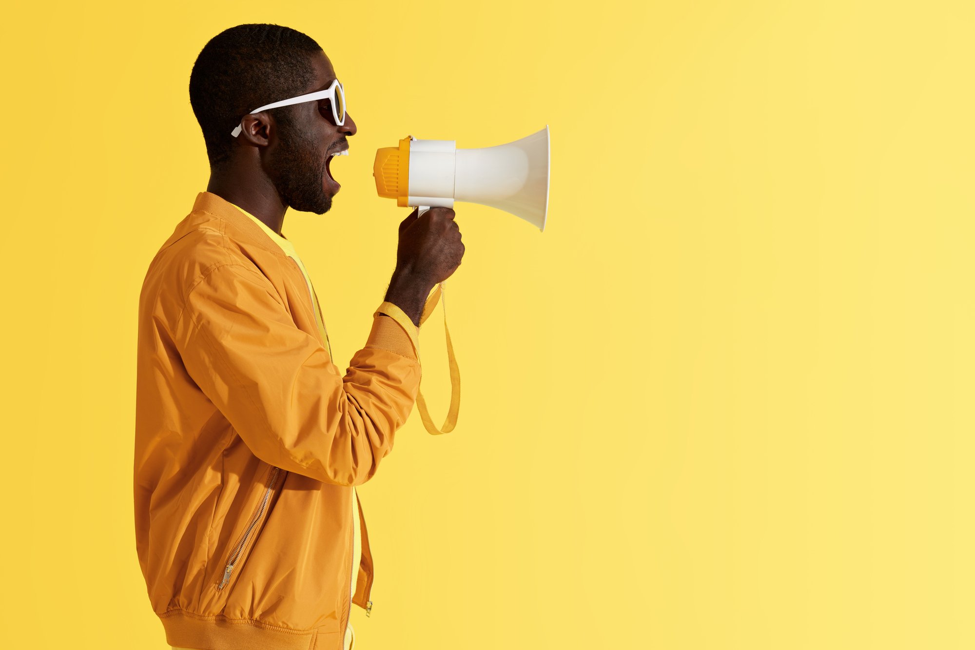 Advertising. Man screaming announcement in megaphone portrait