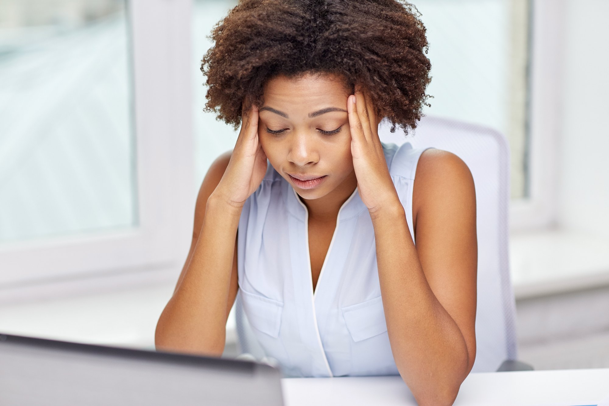 African woman with laptop at office