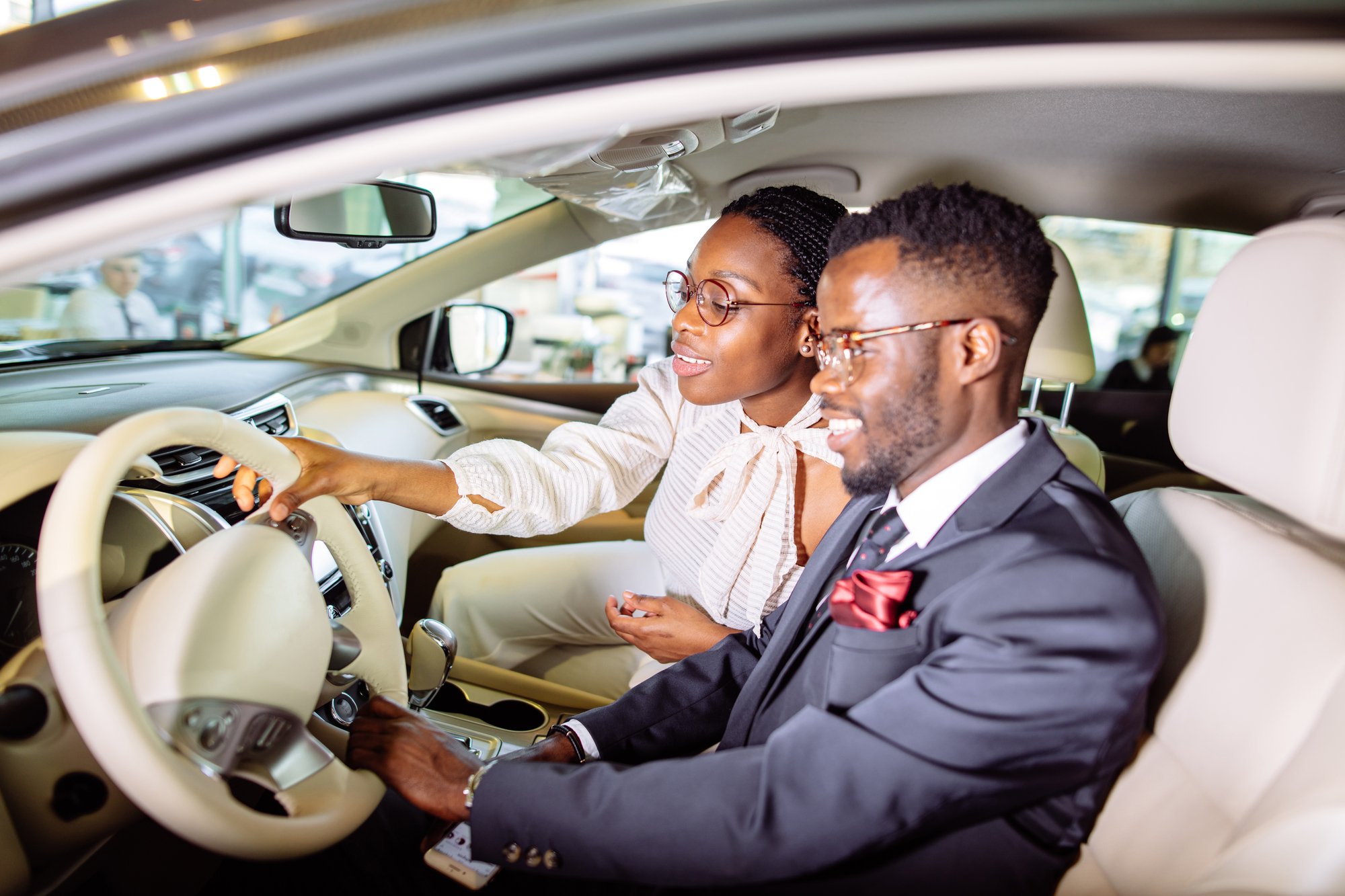 Beautiful african couple is choosing new car at dealership