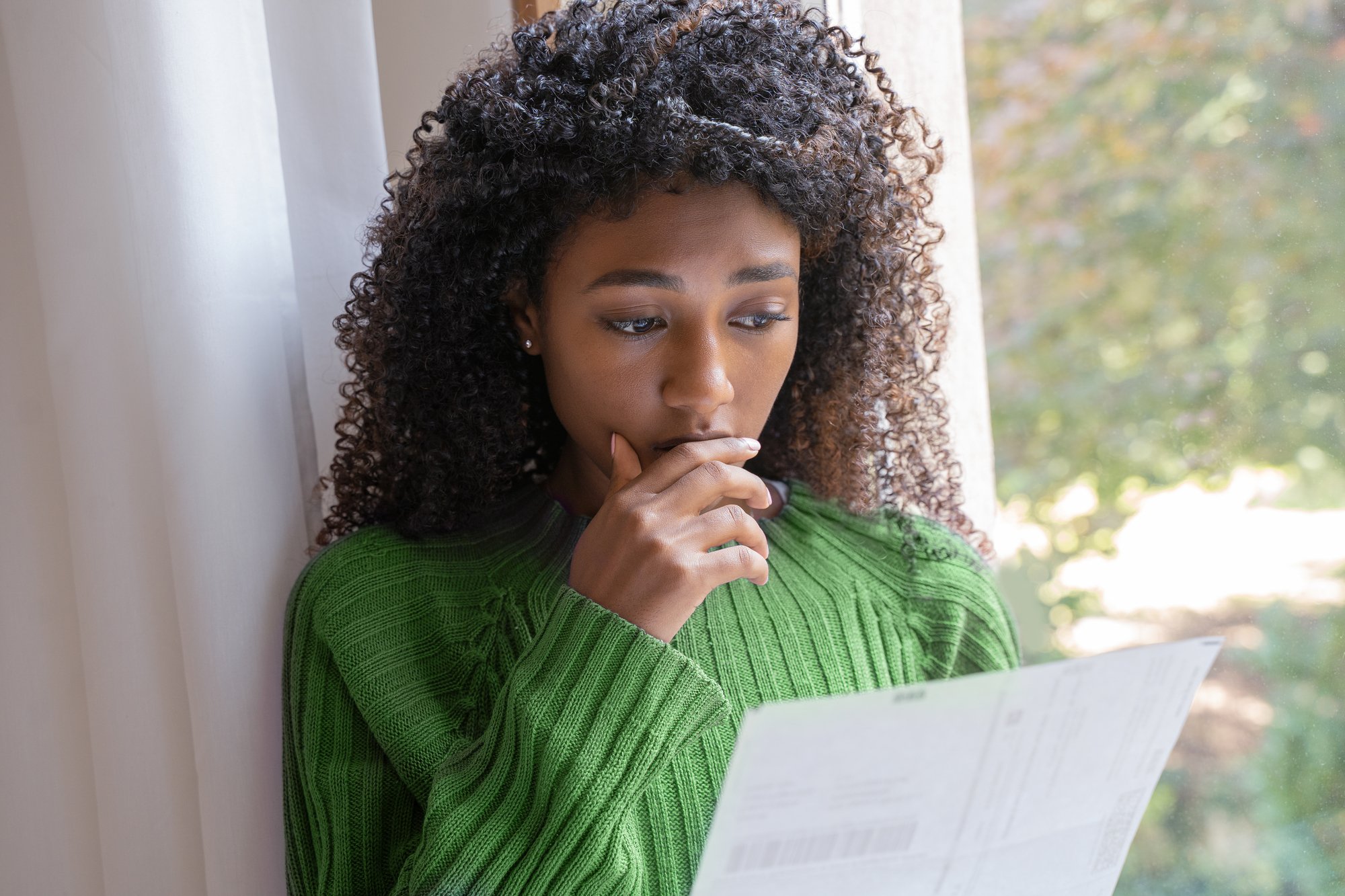 Black woman reading bad news on a letter