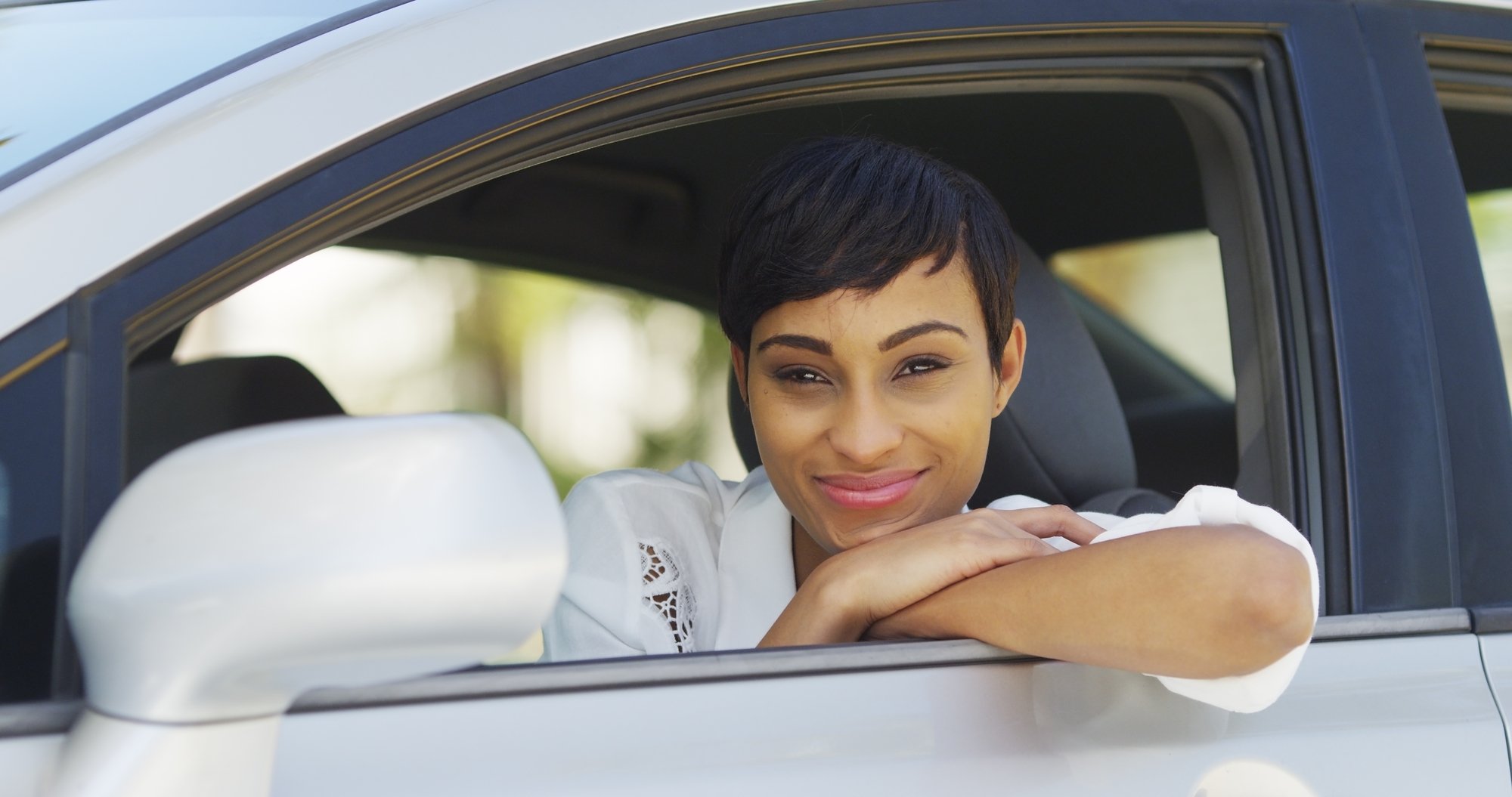 Black woman smiling and looking out of car window