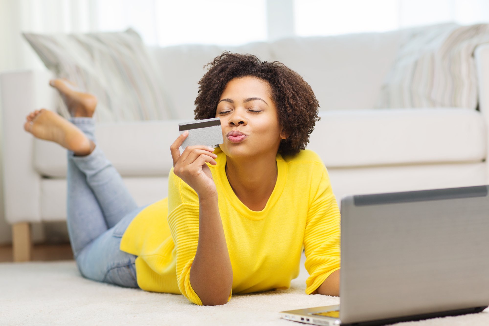 Happy african woman with laptop and credit card