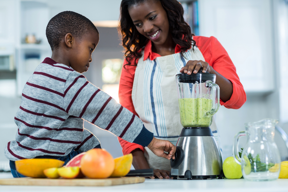 Woman and son using mixer in kitchen