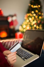Woman shopping online with laptop at christmas at home in the living room
